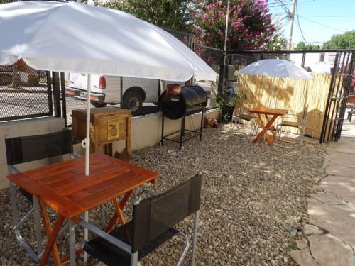 een tafel met een parasol en een tent met een kampeerplek bij Nova Hotel Boutique in Villa Carlos Paz