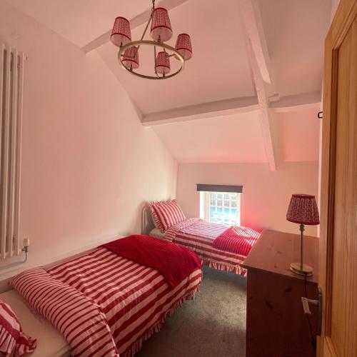two beds in a room with pink walls at Bear Cottage - Waterfall Country in Glyn Neath