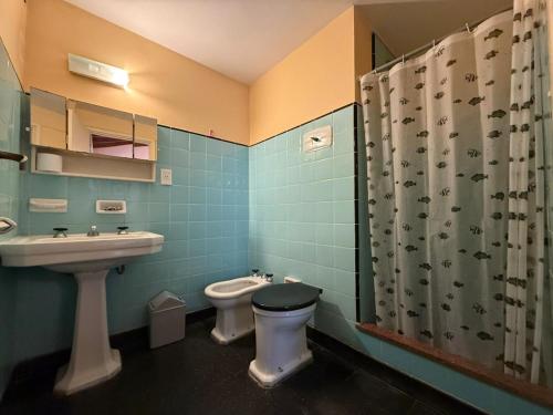 a bathroom with a toilet and a sink and a shower at Hotel Siena Pinamar in Pinamar