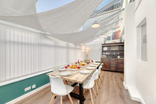 a dining room with a long table and white chairs at Bakers House - 4 Bedrooms - Parking for 3 cars - Dogs welcome in Wells next the Sea
