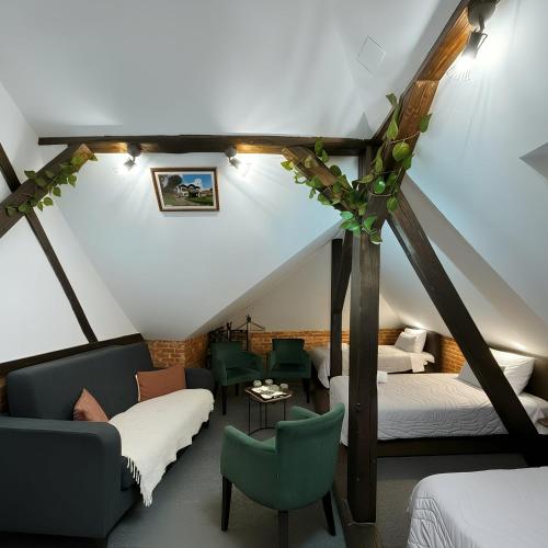 Camera mansardata con 2 letti e un divano. di Hedonia Luxury Rooms a Pirot