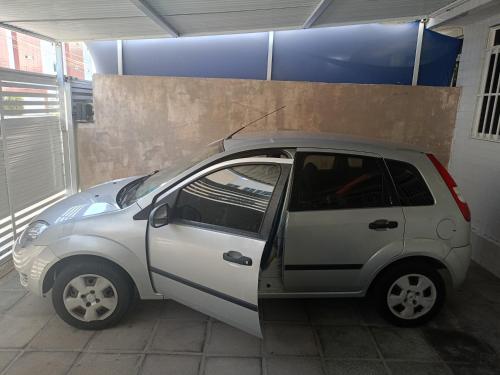 a small car parked in a parking lot at Quarto Aconchegante in João Pessoa