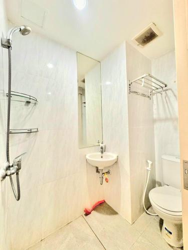 a bathroom with a sink and a toilet and a mirror at Narra Modern Living in Jakarta