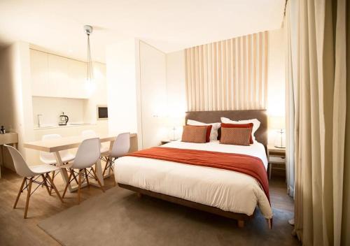 a bedroom with a bed and a table and chairs at Hotel Atlantiis Suites Near Kashi Vishwanath temple in Varanasi