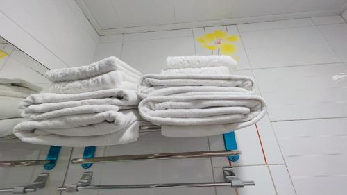a pile of towels on a towel rack in a bathroom at Whouse-sinchon in Seoul