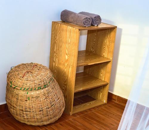 a wooden shelf with two towels and a basket at Tropical lodge in Kakamega