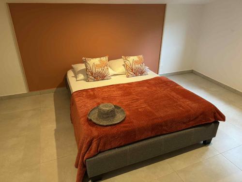 a bedroom with a bed with a hat on it at Villa Canne & Ô in Saint-Joseph