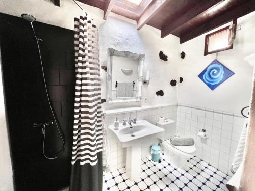 een witte badkamer met een wastafel en een toilet bij Stylish getaway with secluded Patio in lava Finca in Uga