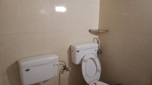 a bathroom with a toilet with the lid up at Shri Homes in Varanasi