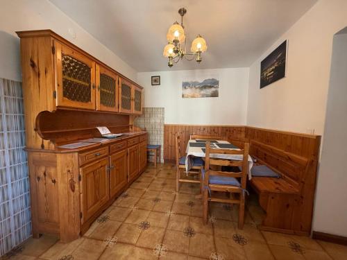 a kitchen with wooden cabinets and a table with chairs at Conveniente, tranquilla con parcheggio in Belluno