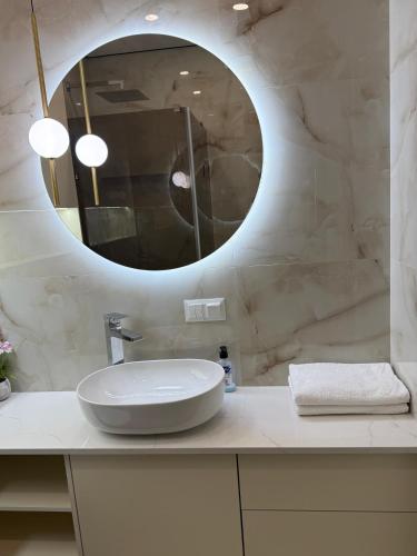 a white bathroom with a sink and a mirror at Apartment Uman in Uman