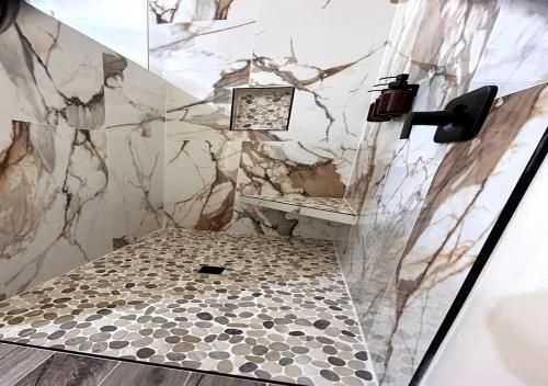 a bathroom with a shower with a tiled floor at Desert retreat 3BR close to River and Casinos in Bullhead City