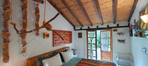 a bedroom with a bed and a wooden ceiling at Jacamaki- Eco-lodge & Reserva Natural in Villa de Leyva