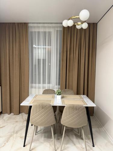 una sala da pranzo con tavolo e sedie bianchi di Apartment Uman a Umanʼ