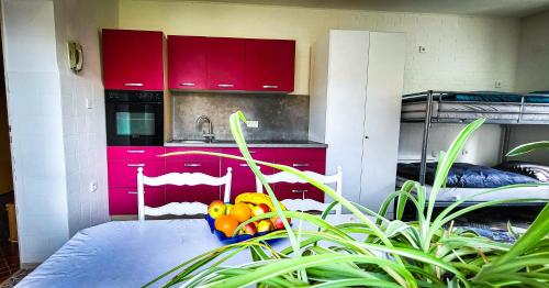 een keuken met rode kasten en een fruitschaal bij Nertha, die Ferienwohnung in Uslar