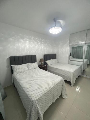 a bedroom with two beds and a chair in it at Byk in Nagua
