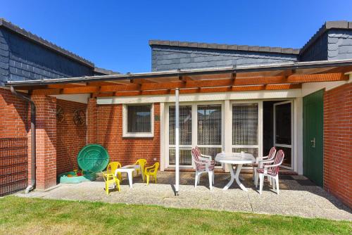a patio with chairs and a table in front of a house at Ferienhaus Wolke 7 in Bensersiel