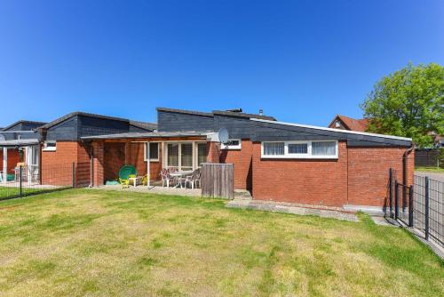 a brick house with a yard in front of it at Ferienhaus Wolke 7 in Bensersiel