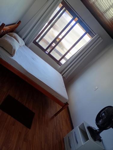 a small room with a bed and a window at Aluguel de Temporada in Arroio do Sal