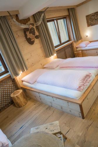 a bedroom with two beds in a log cabin at Atelier Garni Astei in Grossarl