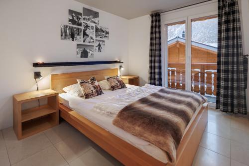 a bedroom with a large bed and a window at Cornelia in Saas-Fee