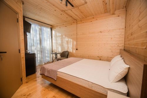 una camera da letto con un letto in una stanza di legno di Kvirike Hills Hotel a Kobuleti