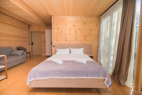una camera da letto con un letto grande e un divano di Kvirike Hills Hotel a Kobuleti