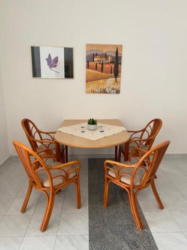 een houten tafel en vier stoelen met een tafel en een schilderij bij Schüler & Simon GbR "Kleine Landvilla" in Meuro