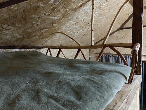 a wooden bed in a room with a wall at Green Paradise in Ijevan