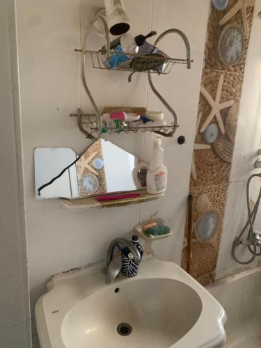 a small bathroom with a sink and a shelf at Simple gem in port said in Port Said