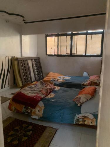 a room with three beds in it with a window at Simple gem in port said in Port Said
