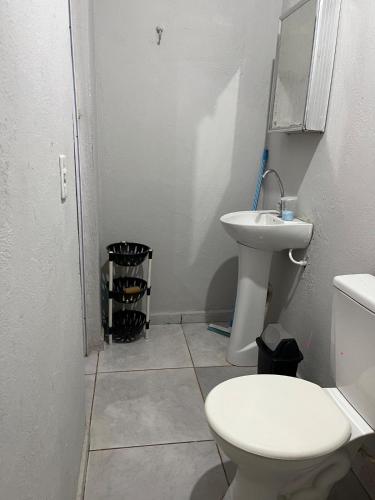 a white bathroom with a toilet and a sink at Casa in São Raimundo Nonato