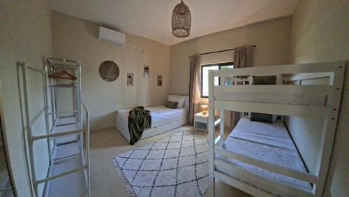 a room with two bunk beds and a ladder at Ka Nicita - Beach house with pool in Praia de Macaneta