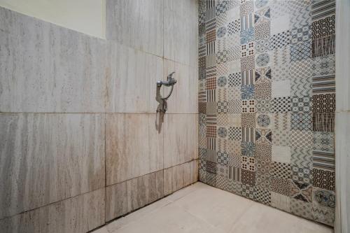 a shower in a bathroom with a tile wall at Collection O Yayah Residence in Bogor