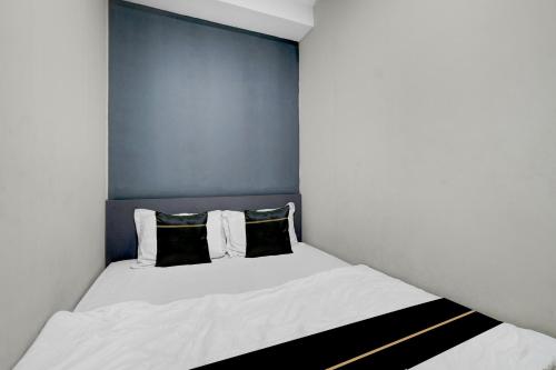 a small bedroom with a white bed with two pillows at Collection O Yayah Residence in Bogor