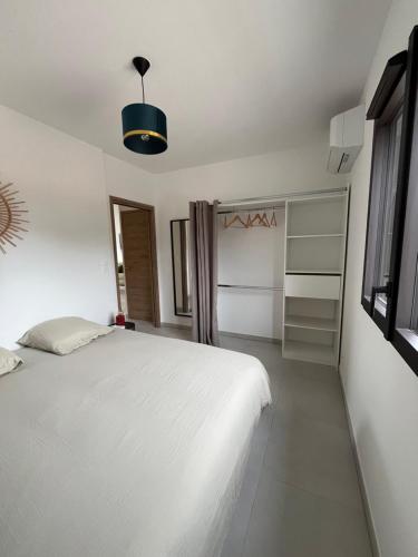 a bedroom with a white bed and a closet at Loc A Machja Fiurita 3 appartements - Pietrosella et Ajaccio in Pietrosella