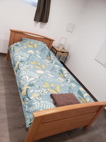 a bed in a room with a blue and yellow pattern at Chambres d'hôtes en Alsace in Sélestat