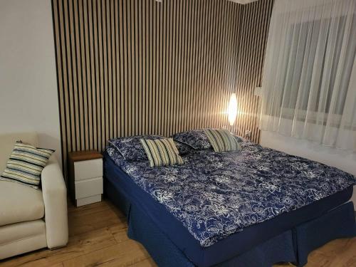 a small bedroom with a bed and a chair at Agrobiskupin Kaczmarek in Gąsawa