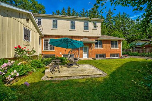 a house with a table and an umbrella in the yard at Charlotte Garden Bed and Breakfast in Niagara on the Lake