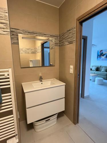 a bathroom with a sink and a mirror at Loc A Machja Fiurita 3 appartements - Pietrosella et Ajaccio in Pietrosella