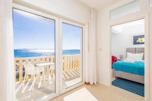 a bedroom with a view of the ocean from a balcony at Apartments Toni 2000 in Podstrana