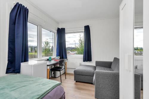 a bedroom with a bed and a desk and a couch at Oddernesveien 7 in Kristiansand