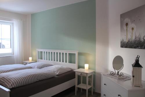 een slaapkamer met een bed, 2 tafels en een spiegel bij Eifler - Sonnenfels in Gerolstein