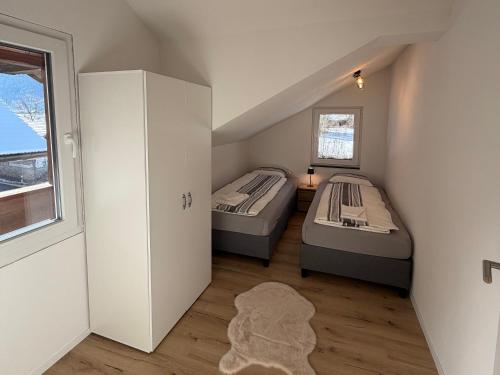 two beds in a small room with a window at Deine Auszeit mit Alpen- und Kanderblick in Kandergrund