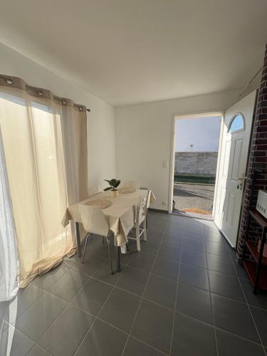 een witte eetkamer met een tafel en een raam bij Maison entière avec jardin , Proche Bordeaux, Rocade et Arkéa Arena in Bouliac