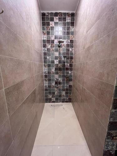 a bathroom with a shower with tiles on the wall at Nile view retreat I in Luxor