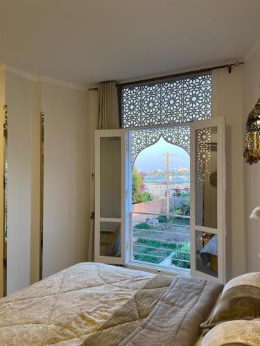 a bedroom with a bed and a large window at Nile view retreat I in Luxor