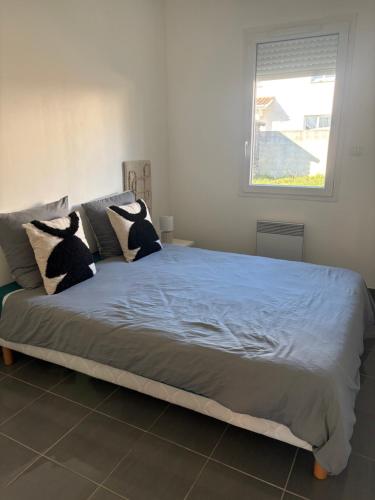 een slaapkamer met een groot bed met blauwe lakens en kussens bij Maison entière avec jardin , Proche Bordeaux, Rocade et Arkéa Arena in Bouliac