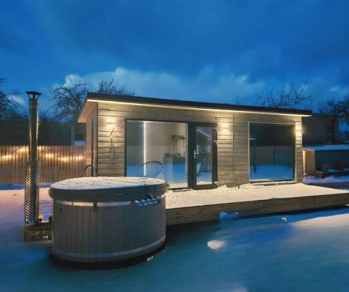 een klein huis met een grote container ervoor bij Kursīšu namiņš in Skulte