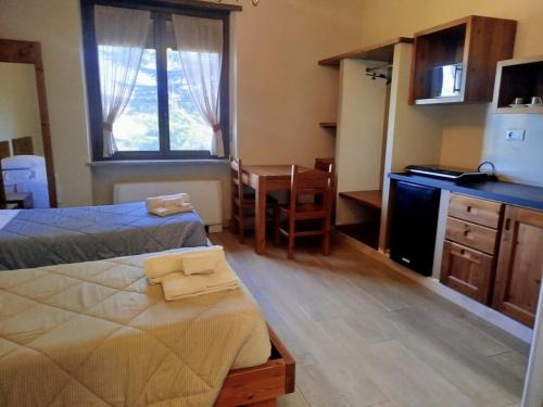 a room with two beds and a kitchen and a desk at La Mandulera in Rivalta di Torino